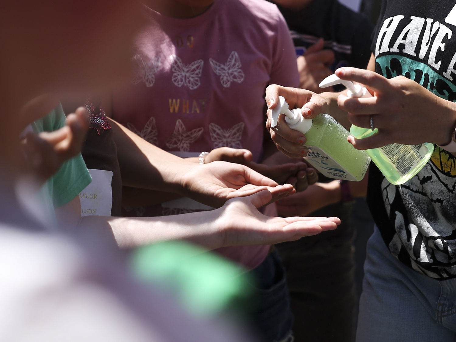 Campers receive hand sanitizer before getting a snack and water for a quick break